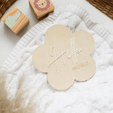 a white blanket with a wooden hello world sign on it